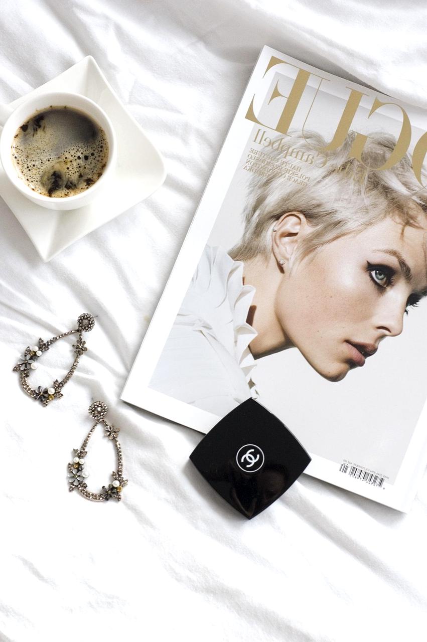 Flat lay of accessories: watch, sunglasses, and hat on white background