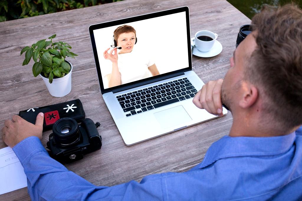 Friendly customer service representative with headphones and laptop