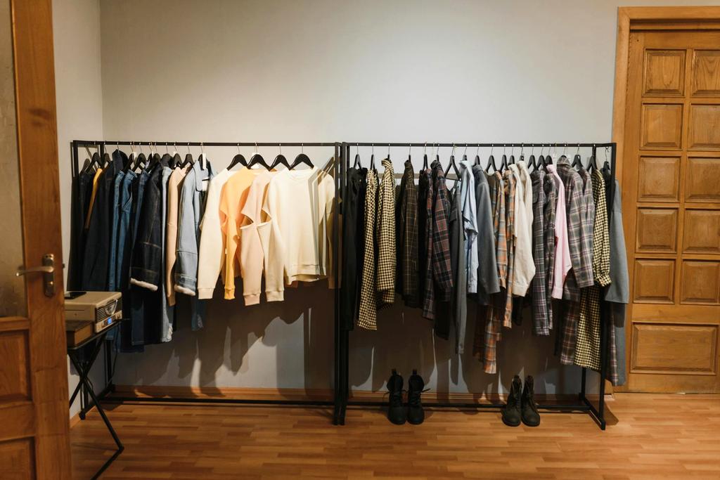 Woman thoughtfully selecting clothes from organized wardrobe